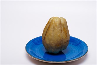 Close-up of a chayote isolated on a white background on a blue ceramic plate