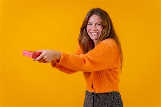 A woman delivering a gift as a surprise on a yellow background