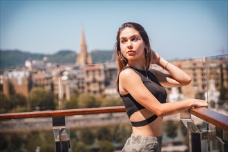 Portrait of a young woman on a hotel terrace looking at the city from above