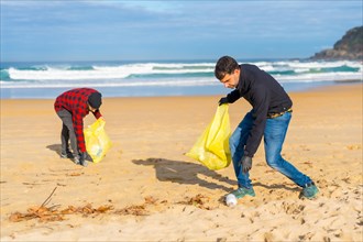 Volunteers collecting plastic on the beach. Ecology concept