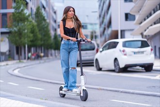 A young brunette woman moving in the city with an electric scooter