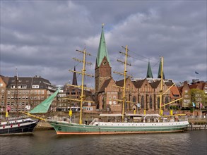 Sailing ship "Alexander von Humboldt" on the banks of the Weser with the red brick buildings of the old town in the background