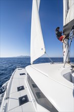 Sailor adjusts the sails on the mast