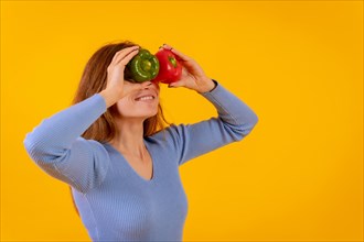 Vegetarian woman with spyglasses of peppers on her eyes on a yellow background