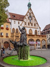 Wedding fountain with green water and Amberg town hall in the background on the Amberg market square