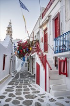 Cycladic white houses with red shutters and bougainvillea