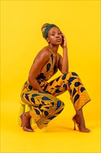 African young woman in traditional dress on yellow background