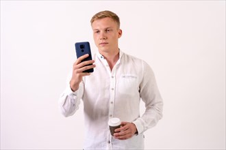 Blond caucasian businessman man with a phone on a white background