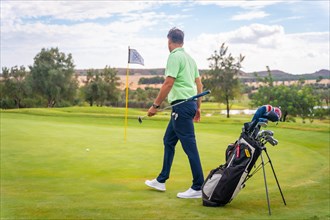 Caucasian professional golf player on the green preparing for the shot