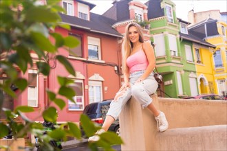 Portrait of blonde tourist in a neighborhood with houses with colorful facades