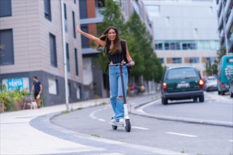 A young brunette woman moving in the city with an electric scooter having fun