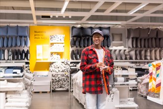 Black ethnic man shopping in a supermarket for almeadas and cushions