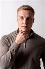 Portrait of a blonde caucasian man with brown sweater on a white background