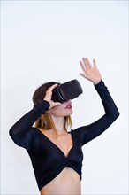 Woman wearing virtual reality goggles on white background