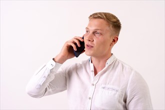 Blond caucasian businessman man talking on the phone on a white background
