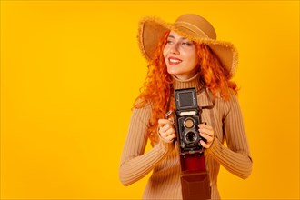 Red-haired woman tourist on a yellow background