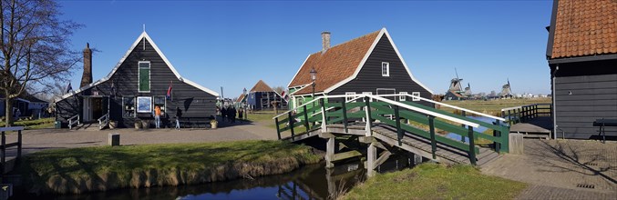 Panoramic photo of Traditional old farmhouse and bridge over a canal in the museum village of Zaanse Schans