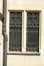 Window with ornate window grille on a house wall