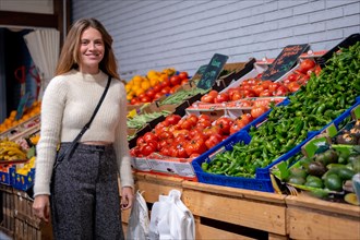 Caucasian woman buying vegetables and greens in grocery store