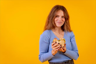 Vegetarian woman holding a sandwich on a yellow background