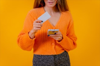 Woman looking at paying with card on internet on mobile phone