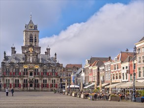 The beautiful Restored Town Hall Stadhuis Delft next to the traditional buildings on the Market Square