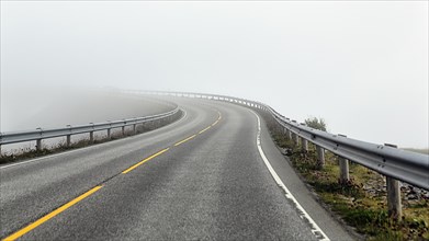 Empty winding road in fog