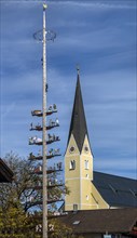 Maypole with the parish church of the Assumption of the Virgin Mary