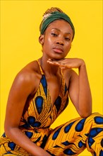 Young african woman with traditional costume on yellow background