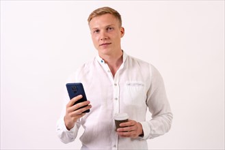 Portrait of a blond caucasian male businessman smiling with a phone on a white background