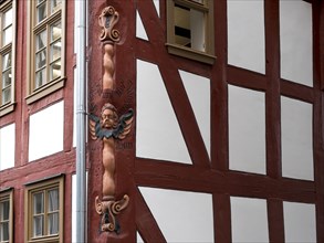 Colourful carved figures on the corner of the half-timbered house