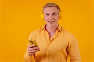 Young blond caucasian man on a yellow background