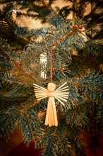 Christmas tree with an angel made of wood on a red thread