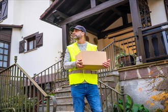 A young delivery man in a protective uniform at the delivery of the online order