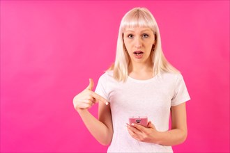 Blonde caucasian girl on pink studio background