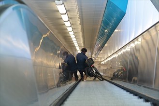 Woman with a bicycle on an escalator in Rendsburg