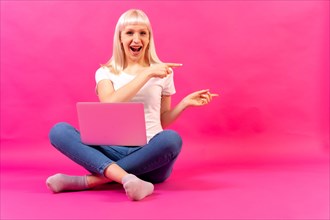 Blonde caucasian girl with a computer