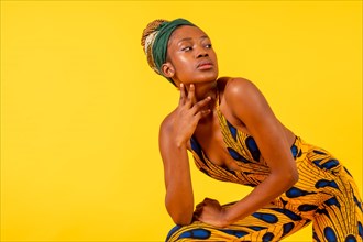 A female person of black ethnicity with traditional costume on yellow background