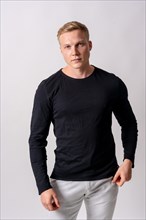 Attractive blonde german model in a black sweater on a white background