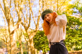 Portrait of red-haired woman with beret in a park