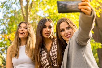 Selfie of women friends smiling in a park in autumn carefree