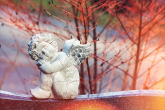 Angel figure sitting on a gravestone