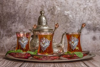 Tray with glasses and serving pitcher of authentic Moorish tea ready to drink with mint leaves