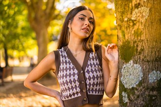 Brunette model in autumn at sunset in a natural city park