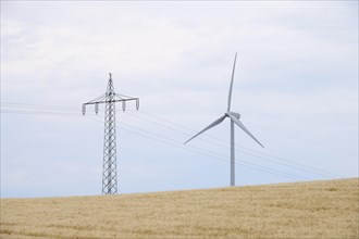Grain field with electricity pole and Windturbine