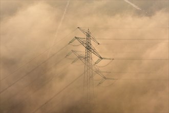 Aerial view of a high-voltage pylon in the fog
