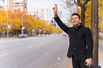Middle aged Caucasian businessman hailing a taxi raising hand to go to work