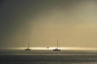 Fog rolling in over sailing boats at sea near the island Ile d'Oleron