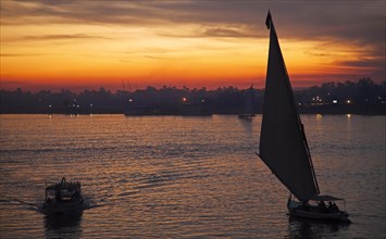 Silhouette of boats sailing on the river Nile at sunset near Luxor