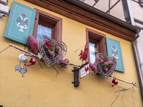 The windows of the yellow building are decorated with colourful hearts